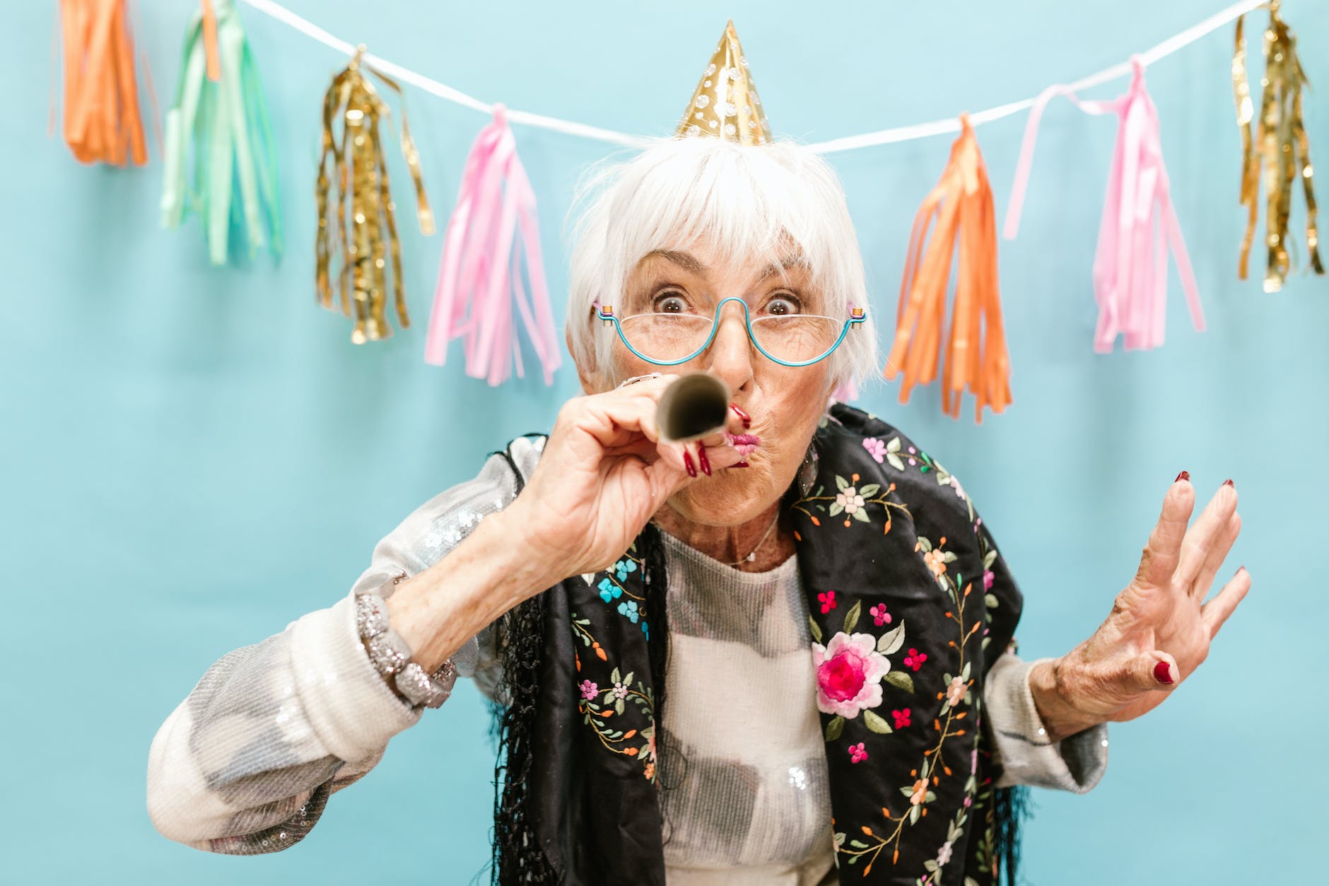 elderly woman blowing a party horn